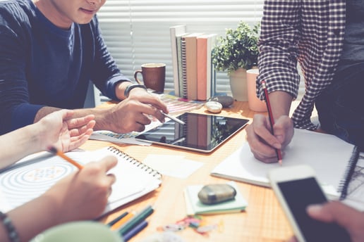 Équipe en réunion autour de documents professionnels en train de digitaliser leur éditique avec FlexiDocs